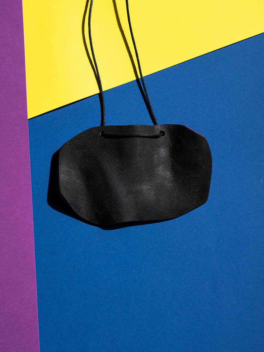 Back black view of a salvaje pendant in magenta, yellow, red, blue and purple colours with strong lighting on a colourful background