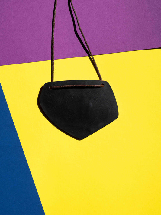 Back black view of a salvaje pendant in magenta, yellow and purple colours with strong lighting on a colourful background